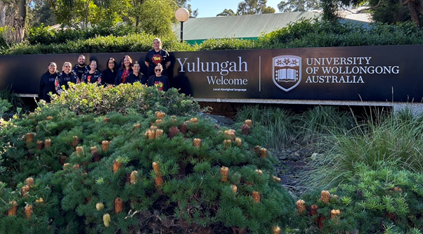 WIC staff posing for photo in front of new language sign