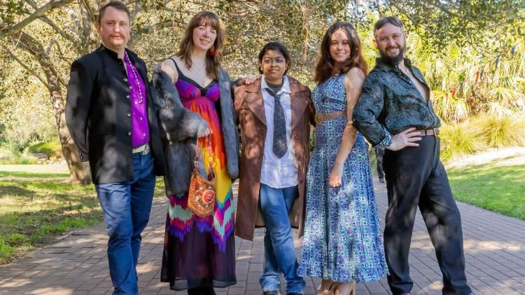 A group of people standing wearing Op Shop clothing
