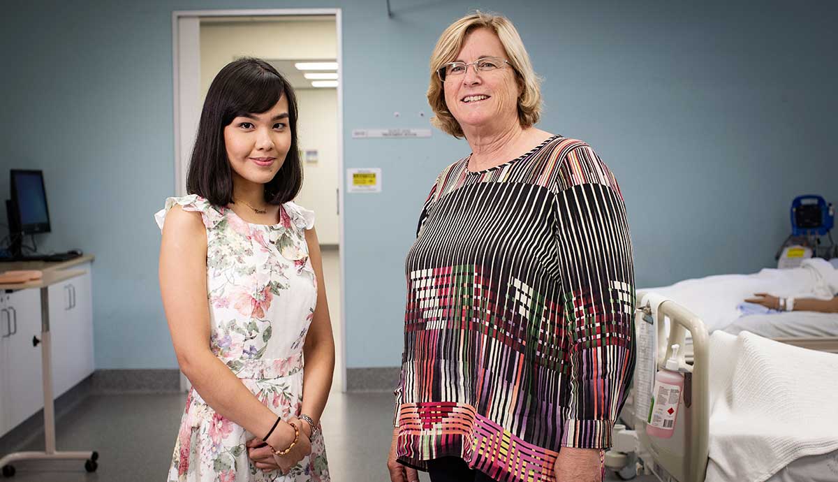 Two women standing in a hospital setting