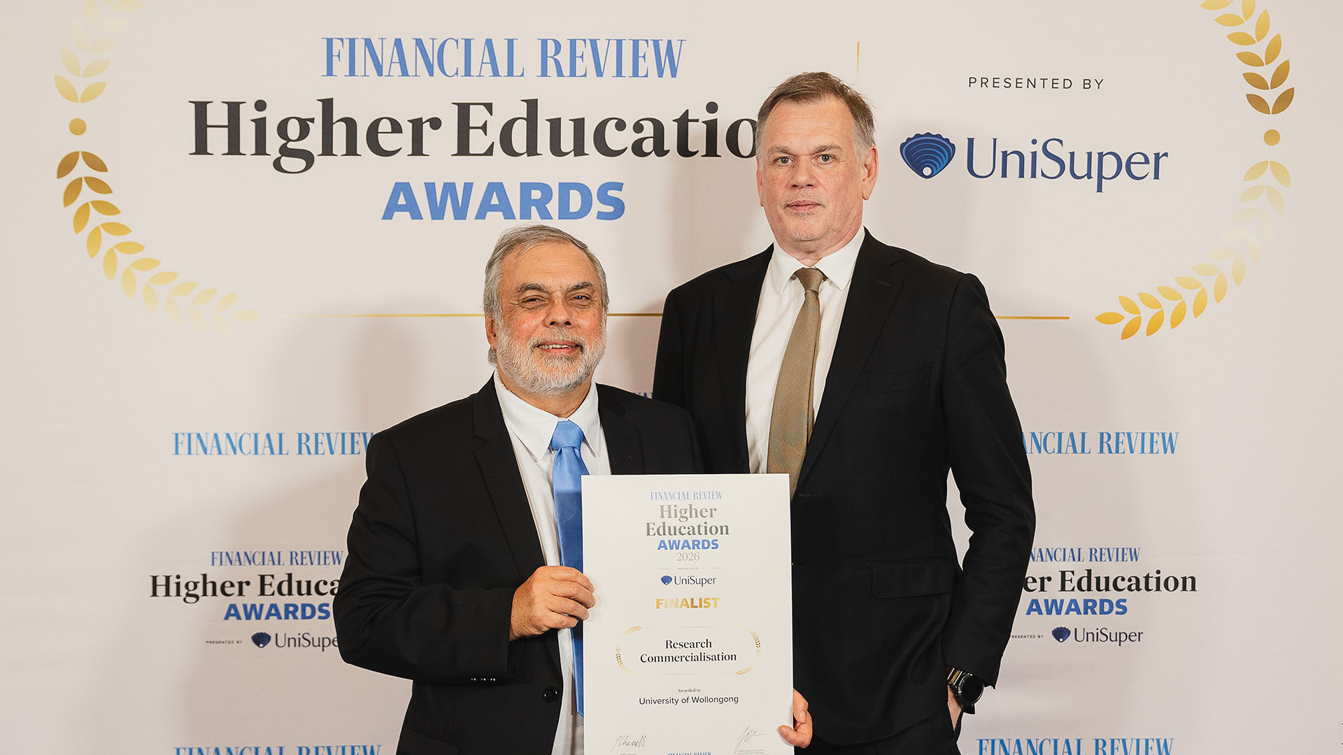 Distinguished Professor Gerry Swiegers and Deputy VIce-Chancellor (Research and Innovation) Professor Alan Rowan on stage at the  2026 Australian Financial Review Higher Education Awards.