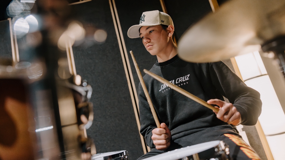 A student from Boorowa Central School plays drums in the UOW recording studio while on a music tour. Photo: Michael Gray