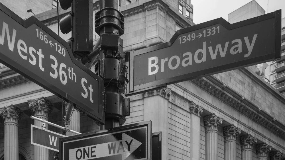 A black and white image of a street sign that says Broadway