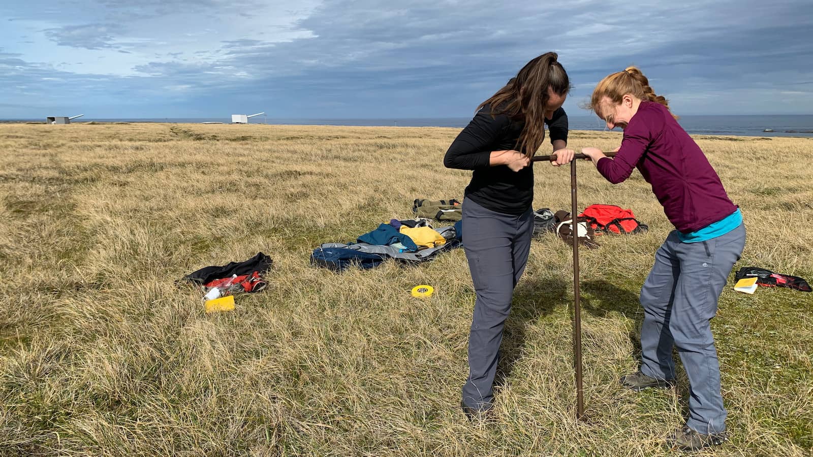 Haidee Cadd and Zoe Thomas use a bore to extract samples from a field of peatlands in the Falkland Islands. Photo: