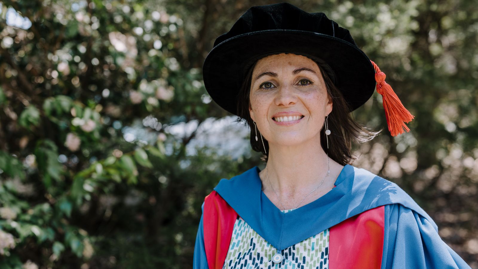 Dr Lilian Ariztimuno smiles at the camera during graduation, October 2024.