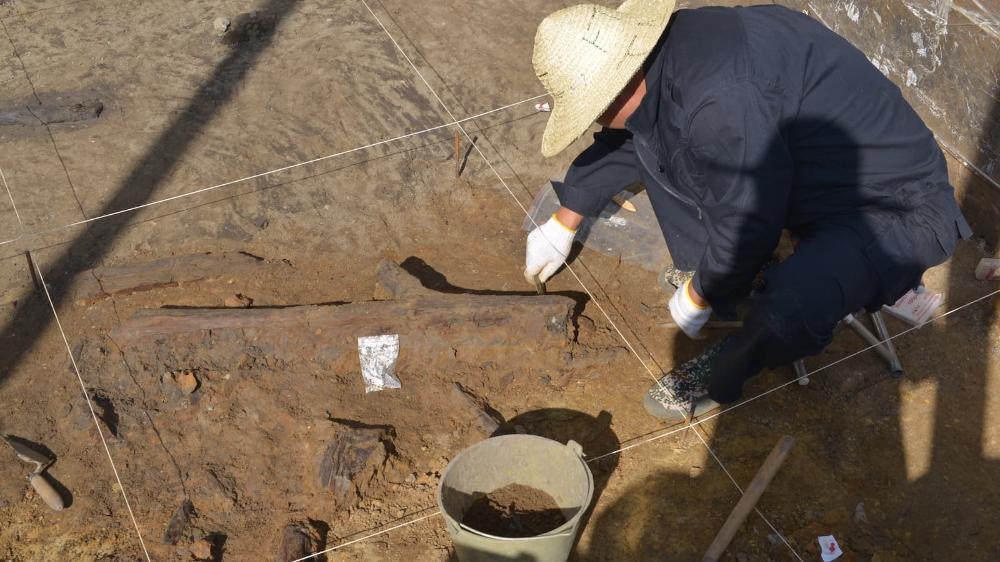 A man is seen digging in the ground on an excavation site. Photo: Bo Li