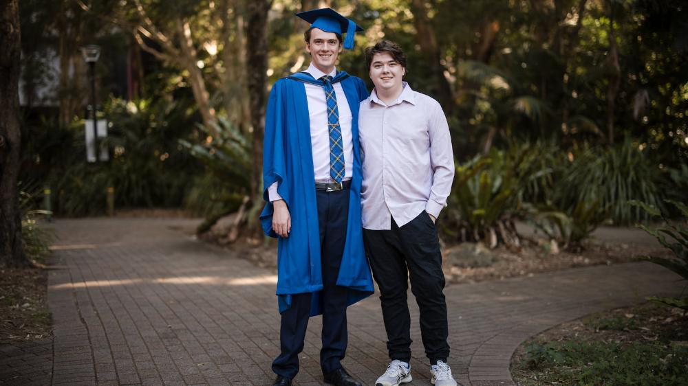 Jackson Cocks, in graduation gown and cap, with his brother Harrison, on Ƶapp campus. Photo: Michael Gray