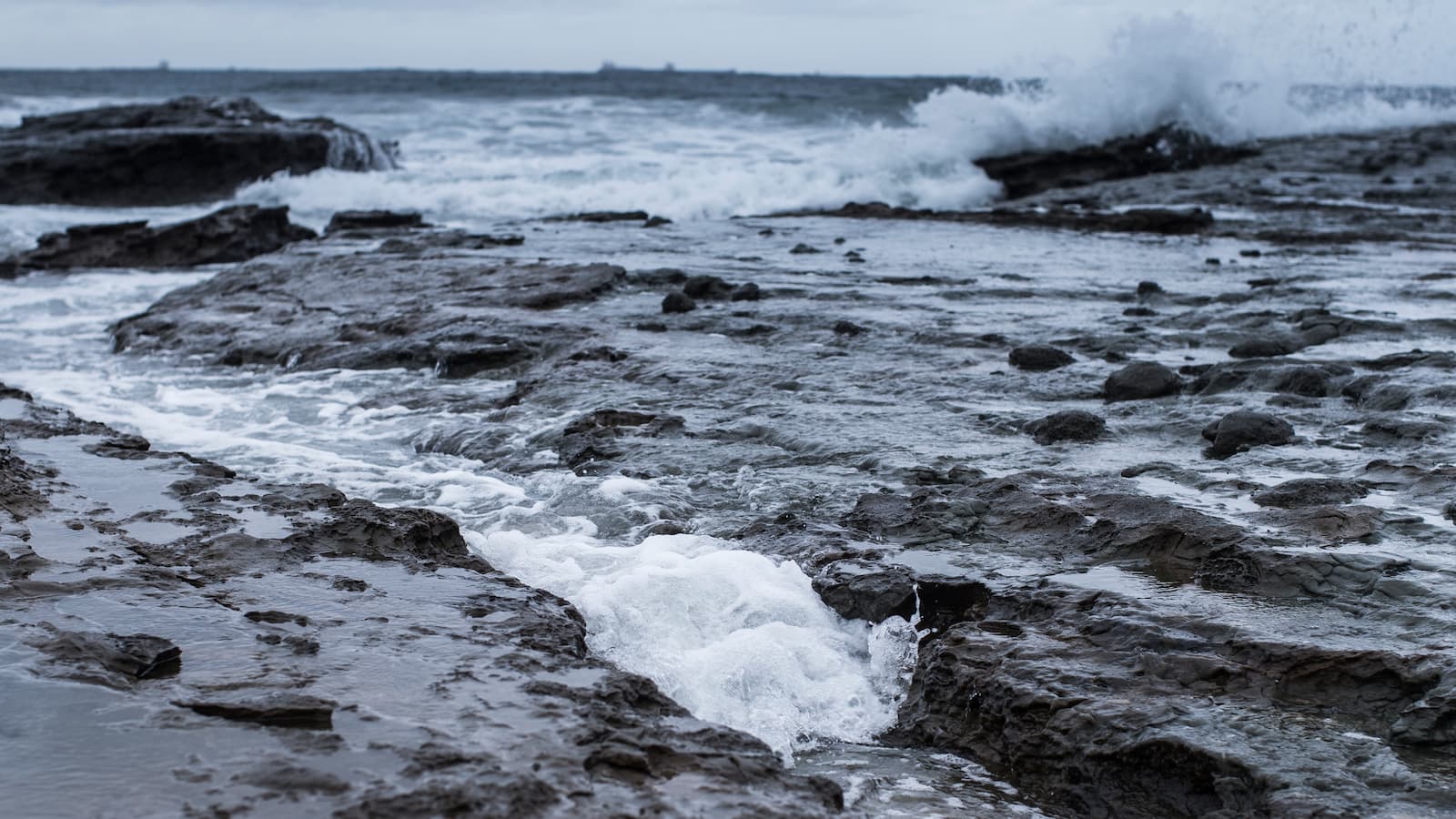 Waves wash against the rocks on a Ƶapp beach. Photo: Paul Jones