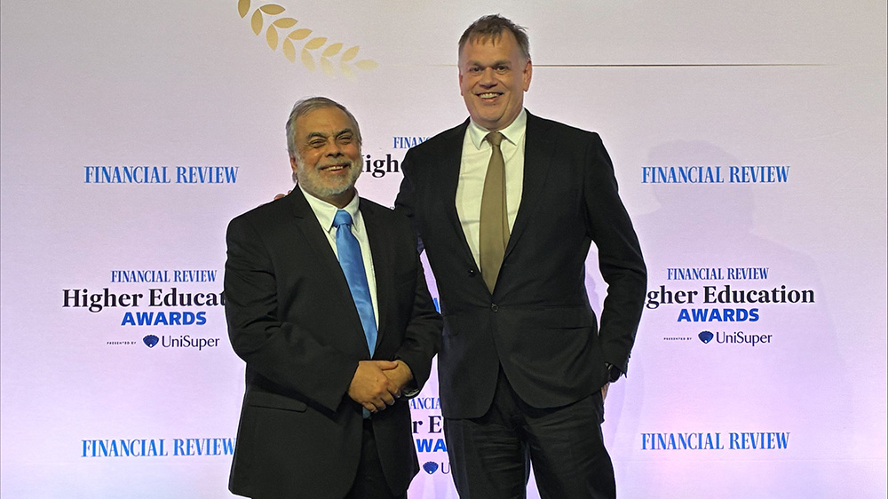 Distinguished Professor Gerry Swiegers and Deputy VIce-Chancellor (Research and Innovation) Professor Alan Rowan on stage at the  2026 Australian Financial Review Higher Education Awards.