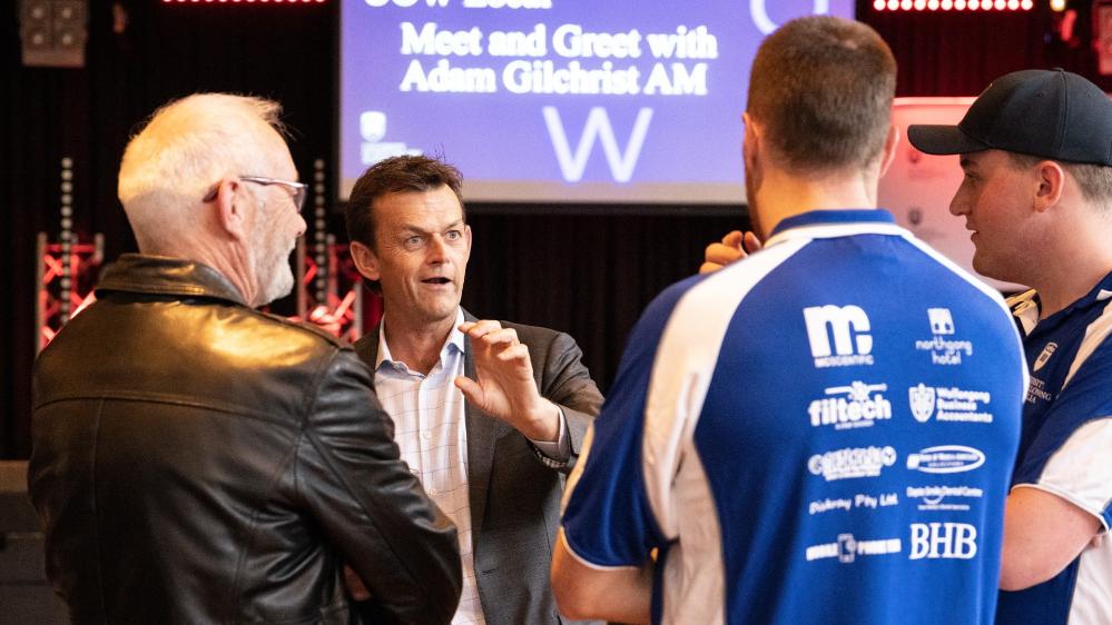 Adam Gilchrist talks to three members of the UOW sporting community during the UOW Local event at UniBar. Their backs are to the camera. Photo: Paul Jones