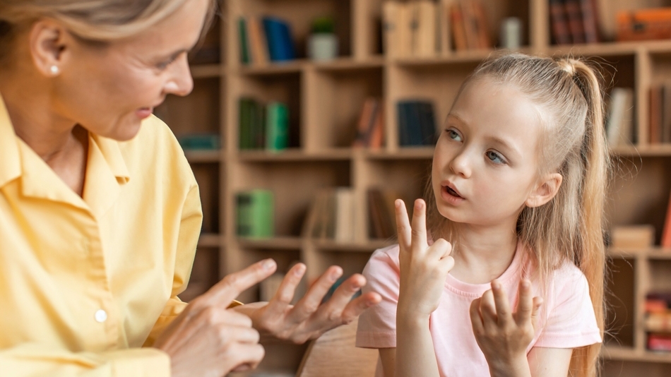 Young girl counting on fingers in a teacher