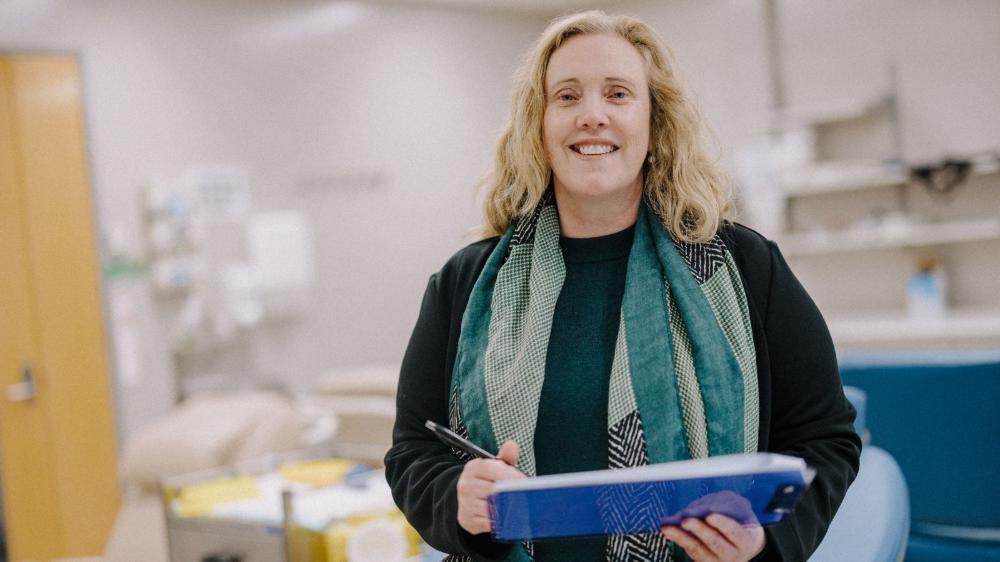 Woman smiling and holding a clipboard
