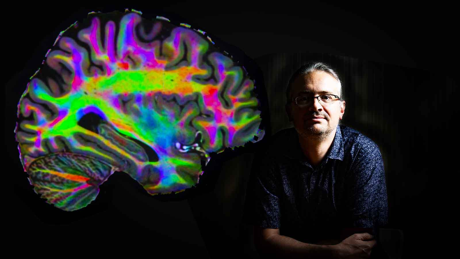 Associate Professor Mark Schira with an image of a brain.