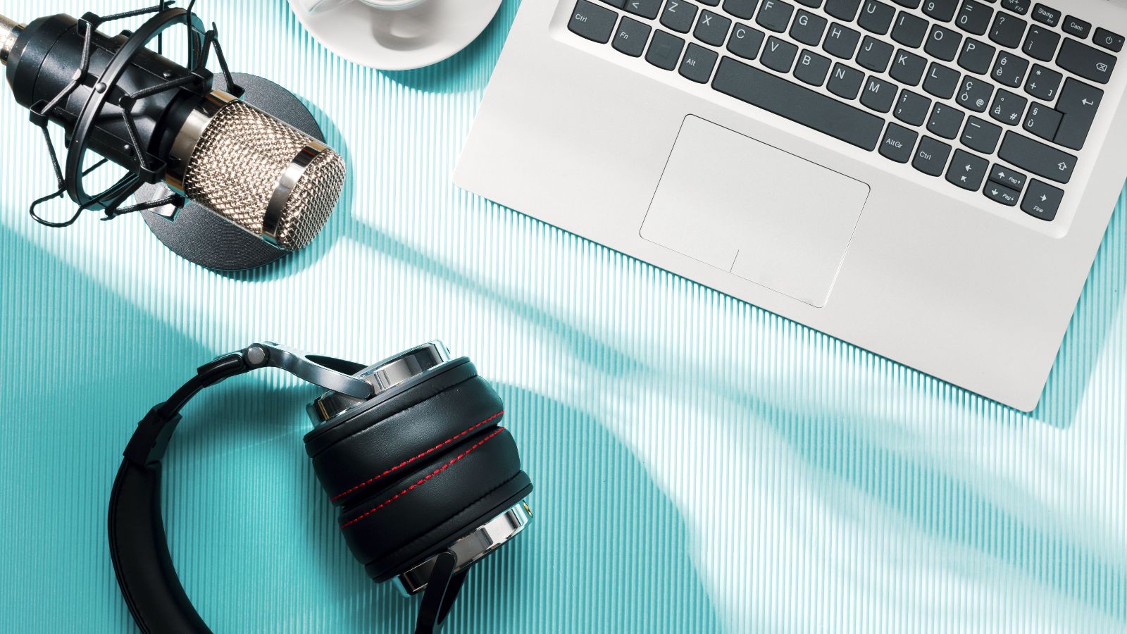 Content creator and podcaster desk with laptop and audio equipment, top view: social media and entertainment concept. Credit: Shutterstock 2557684571