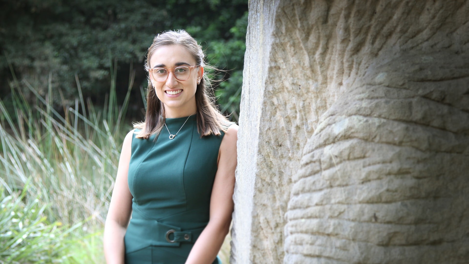 UOW graduate Sophie Whittaker, standing against a tree. Photo: Paul Jones