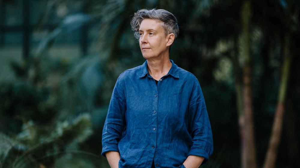 A smiling female wearing a dark blue shirt looks to her right. Photo: Michael Gray