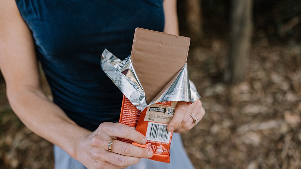 Associate Professor Stephanie Perkiss holds a partially unwrapped block of chocolate.