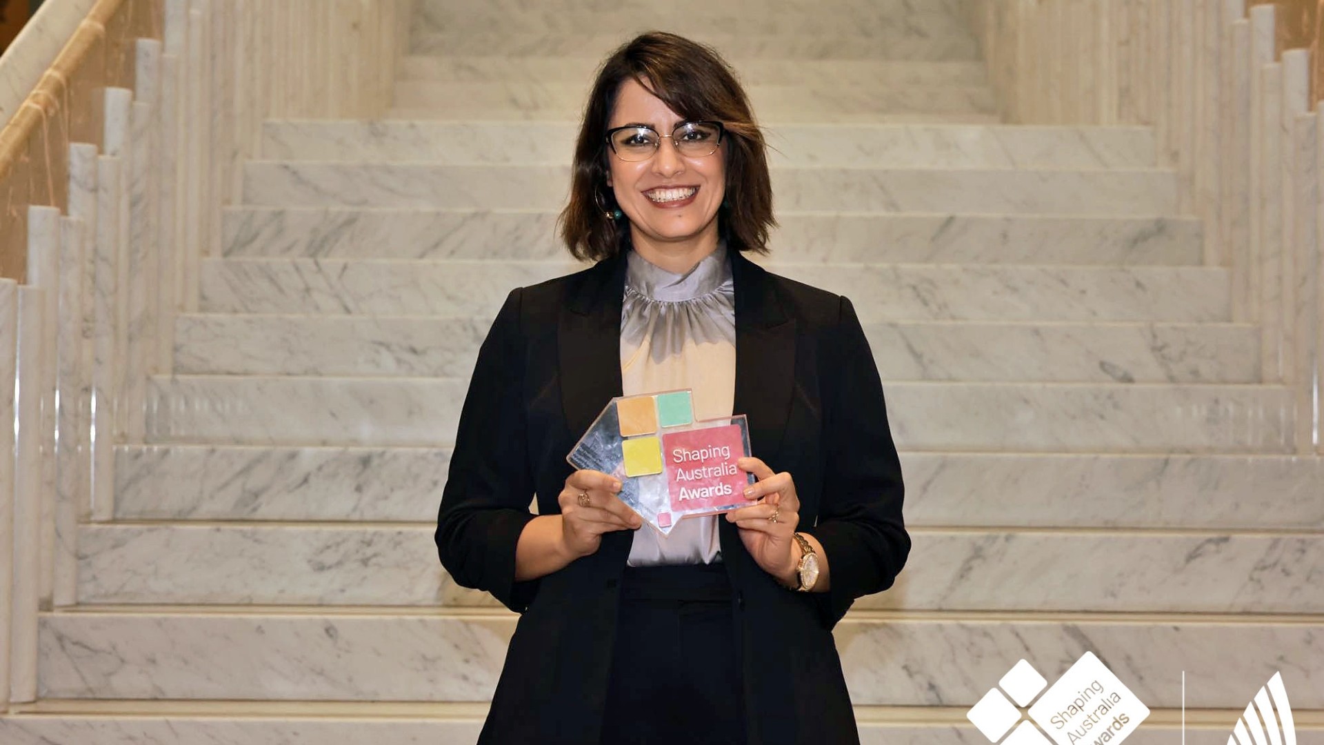 Elahe Minaei smiles holding her Shaping Australia People