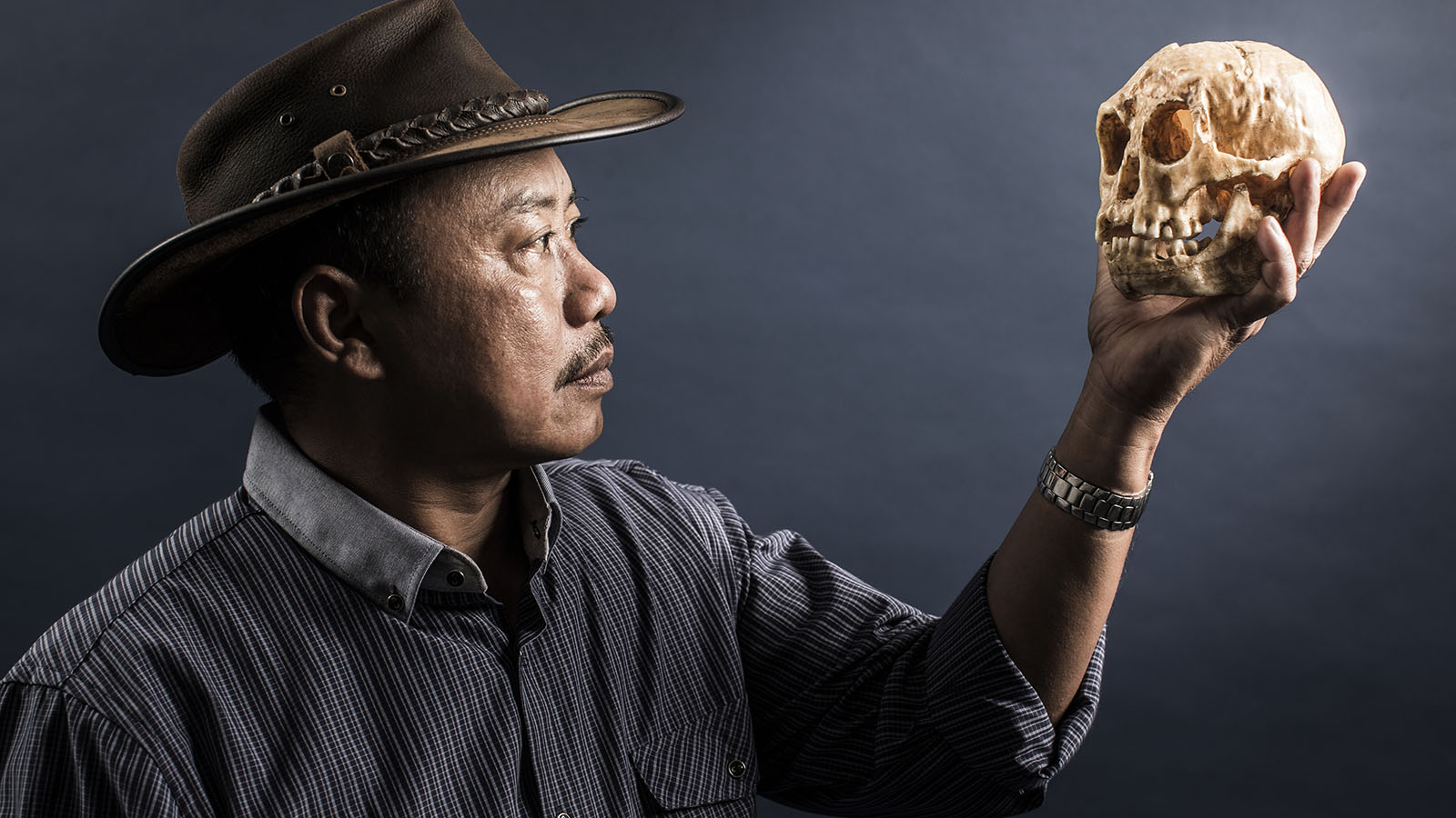 Arcghaeologist Thomas Sutikna with the Homo floresiensis skull found at Liang Bua cave in Indonesia.