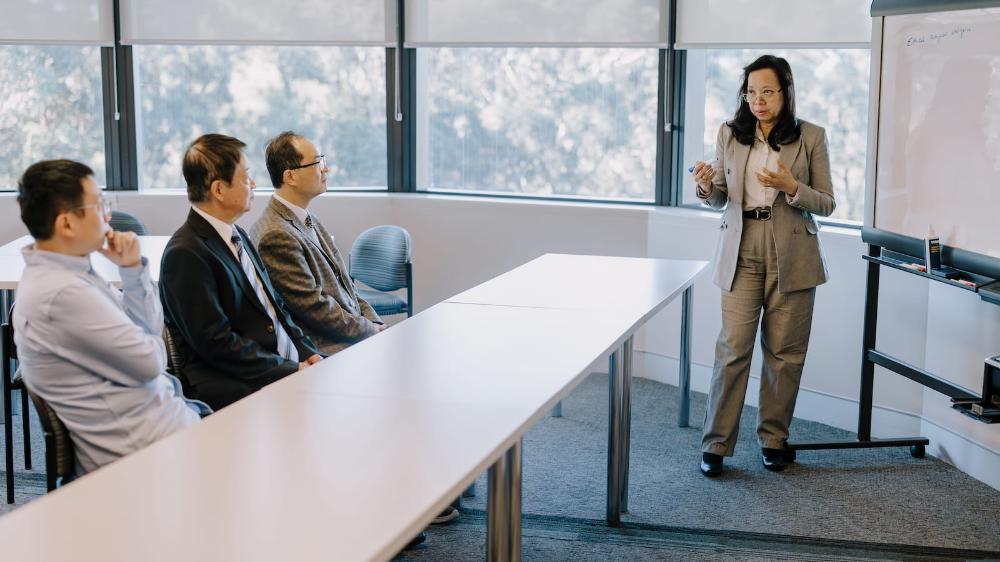 A woman stands at the front of the room talking to a group of researchers. Photo: MIchael Gray