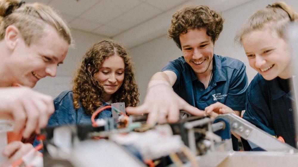 Four students in the workshop building the UOW Rover for the Rover Challenge 2024. Photo: Michael Gray