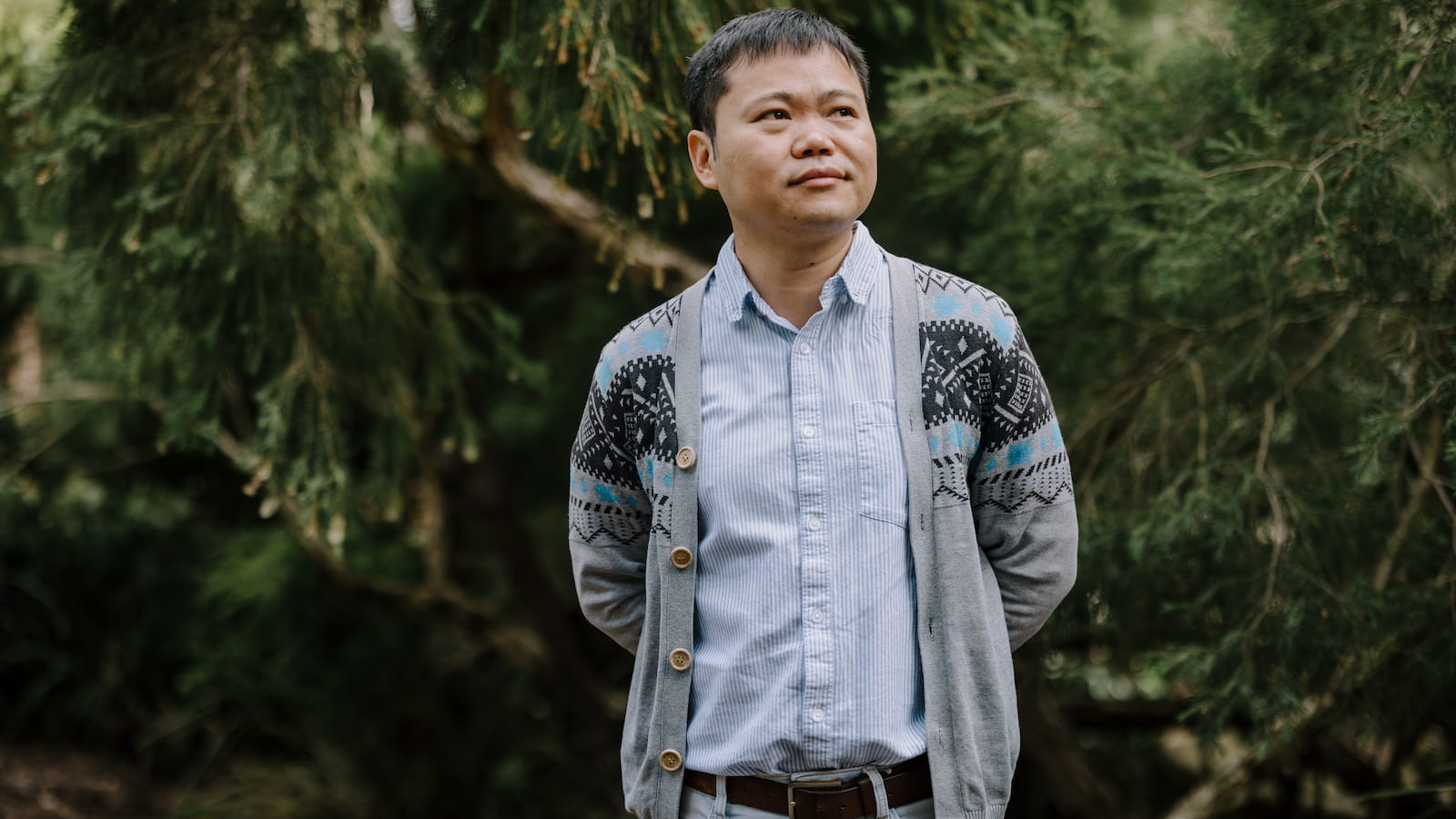A man stands in front of a group of shrubs. Photo: MIchael Gray