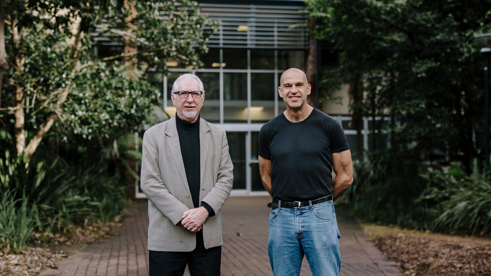 Two men stand in front of a building. Photo: Michael Gray