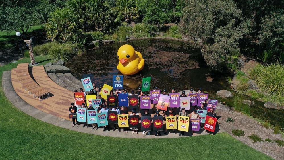 UOW staff hold Yes signs at Ƶapp Campus, with the giant blow up duck in the background. Photo: Tad Souden