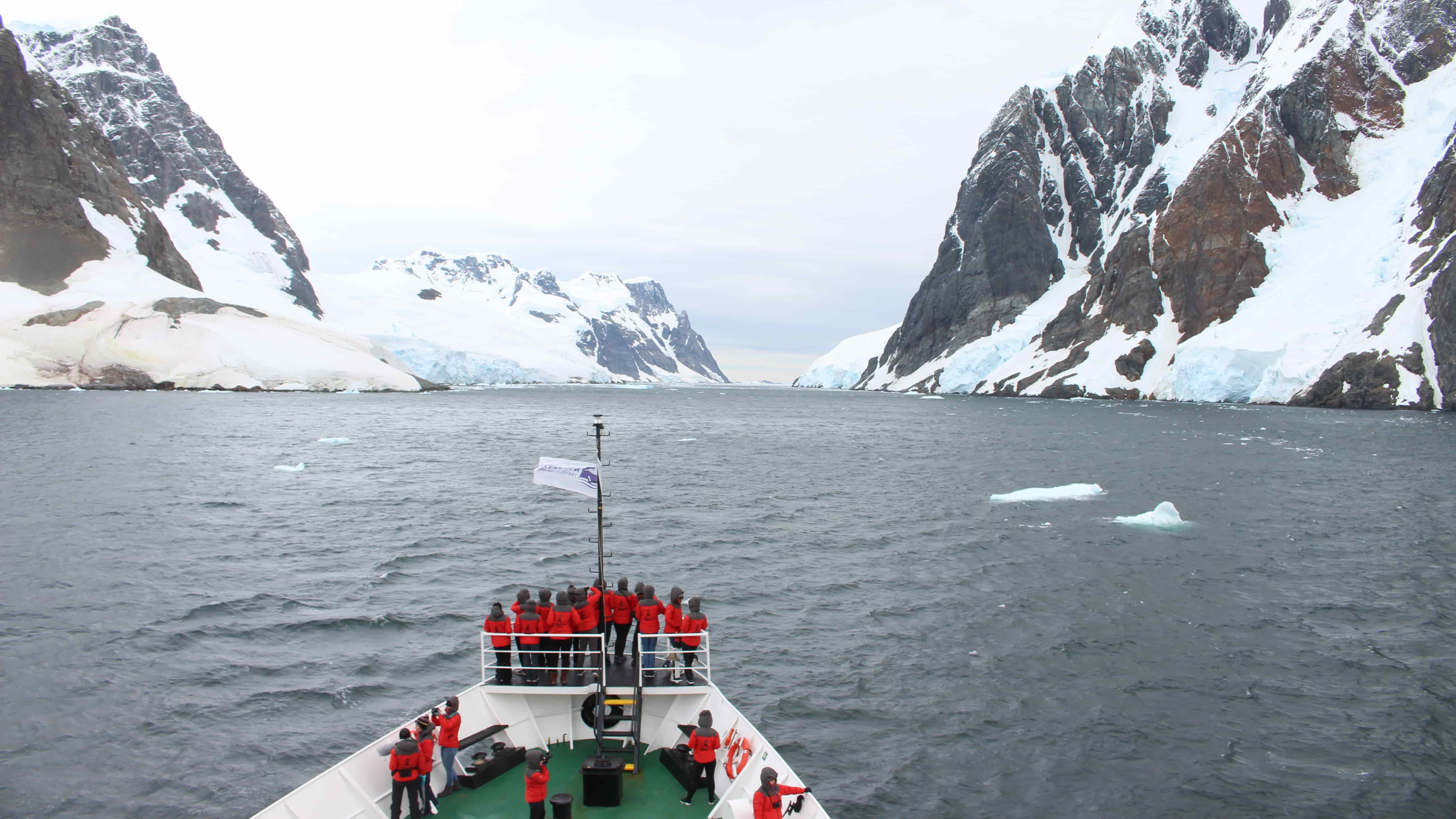 Researchers wearing red jackets stand aboard the Homeward Bound ship as it navigates the waters of Antarctica. Photo: Rachelle Balez