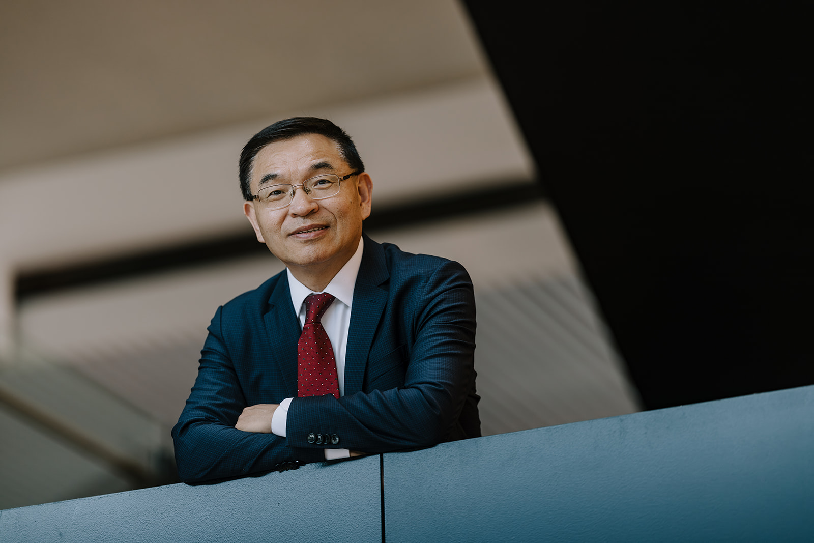 New Vice-Chancellor Professor Max Lu leans against the staircase