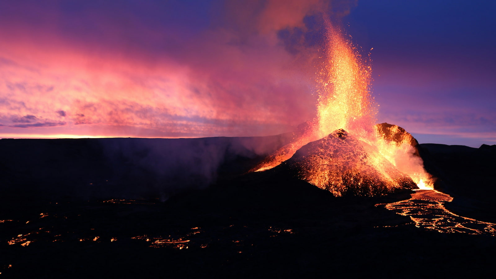 A volcano spews hot magma with the sun setting in the background. Photo: Izabela Kraus/Unsplash