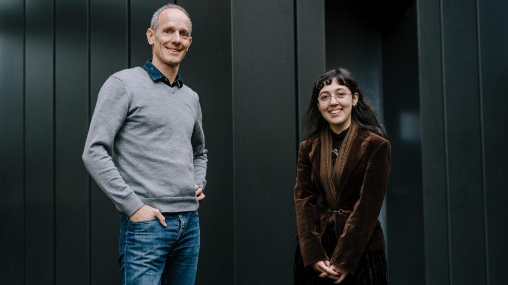 A man and a woman stand casually outside a black building. Photo: Michael Gray