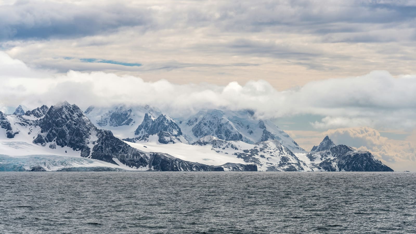The ice-covered mountains of Elephant Island in Antarctica loom over the water. Photo: Paul Carroll/Unsplash