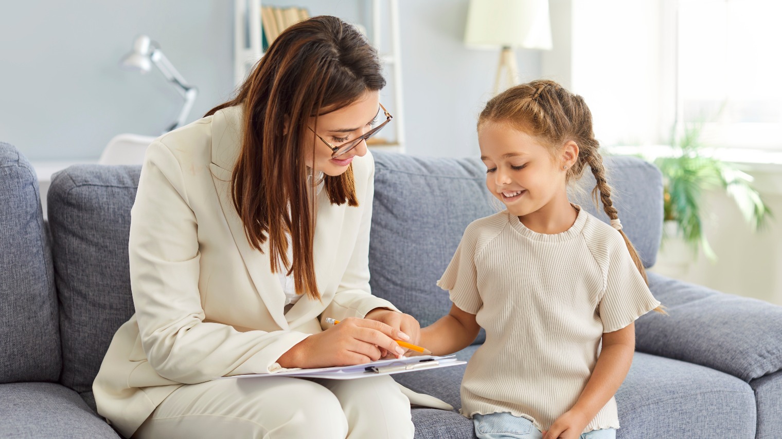 Doctor psychologist talks with a young girl during a therapy session. Credit: Shutterstock
