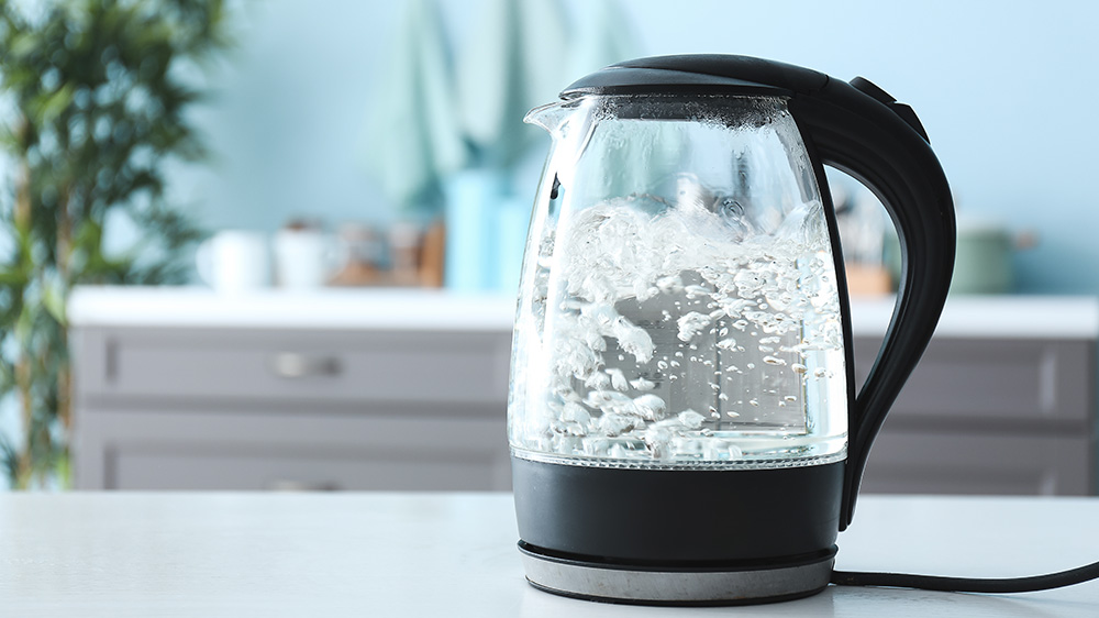 Water boiling in a see-through electric kettle.