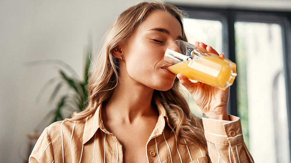 A young women drinks an orange juice cocktail
