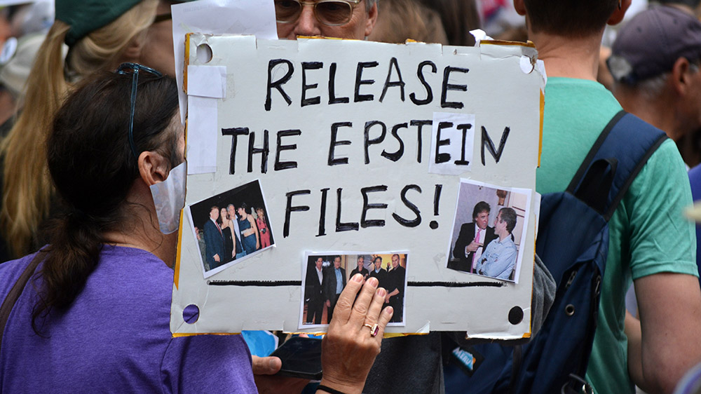 A protestor holds a sign saying 