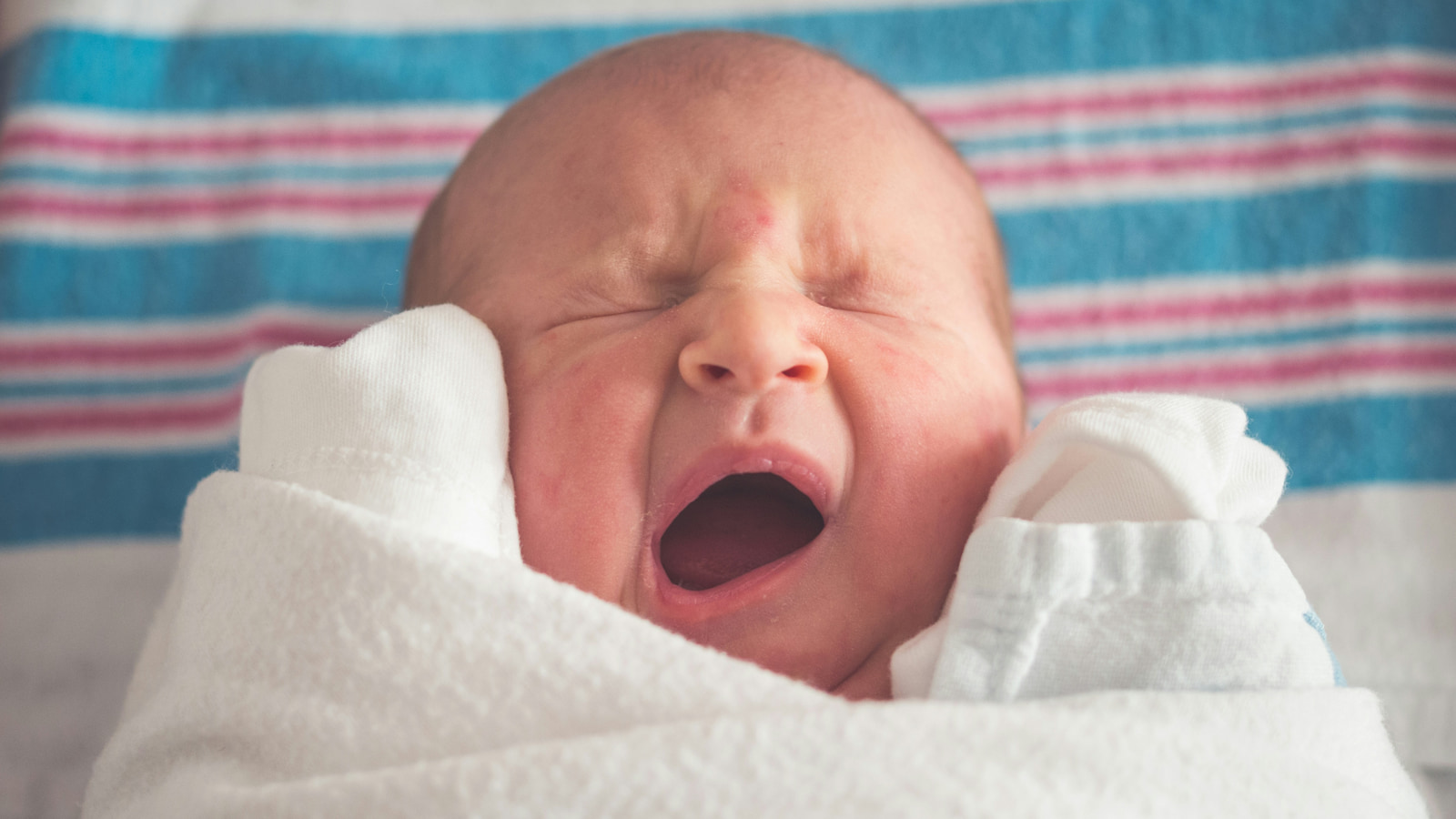 A newborn baby is wrapped in a hospital blanket. Photo: Unsplash