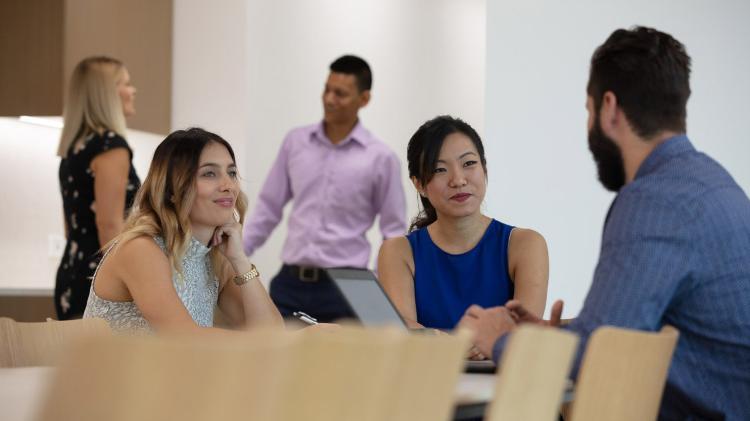 Students at table and standing in background